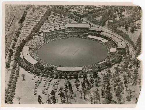 'Bodyline'. M.C.C. tour to Australia 1932/33. Large original mono press photograph of an aerial view of the Melbourne Cricket Ground seen with large crowds in attendance and a packed car park in the background. The photograph appears to have been retouche