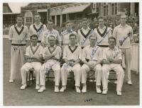 Lancashire C.C.C. 1950 County Championship joint winners. Official mono press photograph of the Lancashire team seated and standing in rows wearing cricket attire, the Old Trafford pavilion and spectators in the background. Very nicely and uniformly signe