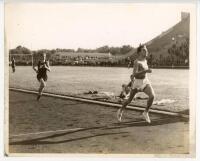 Athletics. Jack Lovelock (New Zealand) and Archie San Romani (U.S.A.) 1936. Original mono press photograph of Romani crossing the finishing line ahead of Lovelock in a race over one mile at Palmer Stadium, Princeton, N.J. in 1936. Agency stamp to verso fo