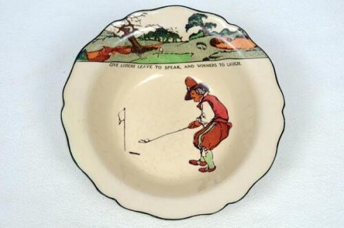 Royal Doulton 'Golfing series' 1911-1932. A large bowl with scalloped edge, decorated in colour with cavalier figures (Charles Crombie) playing golf with inscription 'Give losers leave to speak and winners to laugh'. Colour golf course border to top borde
