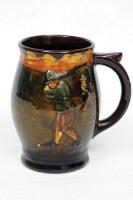 Charles Crombie. A Royal Doulton Kingsware golfing tankard of baluster form, moulded in relief with a scene of Crombie golfers, dark treacle finish. Royal Doulton mark to base. 5.25&quot; tall. Good condition - golf