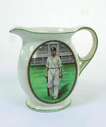 Jack Hobbs. Surrey &amp; England. New Hall Pottery white water jug, printed with an oval colour portrait of Hobbs wearing England cap walking out to bat with stands to background. Crossed bats, stumps and cricket balls on crest to verso. Circa 1930. Appro