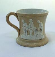 Cricket mug. A small Staffordshire 3&quot; waisted cricket mug with strap handle and beaded rim, with cream background and three raised figures in white of a batsman, bowler and wicket keeper, believed to be Lillywhite, Pilch and Box. c1870. Unusually the
