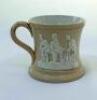 Cricket mug. A small Staffordshire 3" waisted cricket mug with strap handle and beaded rim, with cream background and three raised figures in white of a batsman, bowler and wicket keeper, believed to be Lillywhite, Pilch and Box. c1870. Unusually the