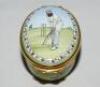 'W.G. Grace'. Halcyon Days oval enamelled pill box. The lid decorated with full length figure of Grace in batting pose wearing M.C.C. cap, history of cricket details to the inside of the lid 'Played in England since the 13th century...', the inside base w