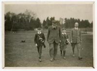 W.G. Grace. Original mono photograph of Grace playing golf. Grace is depicted walking on the fairway accompanied by one other and two boys as caddies. Pencil annotation to verso described 'Old cricketers v Mortons School staff. Dr. W.G. Grace &amp; Master