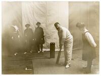 George Burton. Middlesex 1881-1893. Original mono photograph of Burton in batting stance at the wicket in an indoor setting, with ladies looking on. To the verso, a pencil inscription reads, 'Ladies learning to play cricket. At the Hampstead Baths in the 