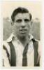 Len Quested. Fulham &amp; Huddersfield Town 1947-1957. Mono real photograph plain back postcard of Quested, head and shoulders, wearing Huddersfield Town shirt. Signed in blue ink to the photograph by Quested. Photographer unknown. Small bump to one corne