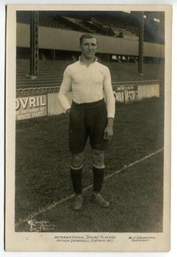 Arthur Grimsdell. Tottenham Hotspur 1912-1929. Early mono real photograph postcard of Grimsdell, full length, in Spurs attire in front of the main stand. To lower border is the title 'International 'Spurs' players. Arthur Grimsdell (Captain 1921). 'W.J. C