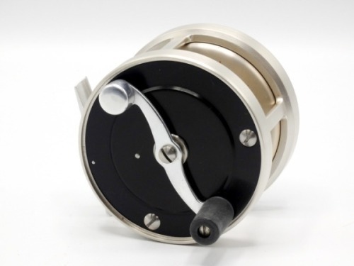 A fine and rare S.E. Bogdan model 150 salmon fly reel, left hand wind model with black anodised end plates, counter-balanced serpentine “S" scroll crank winding arm, alloy foot, stamped model details, rear milled alloy optional check button and ten point