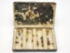 A black japanned rectangular fly box, lid white painted “F.M.H.", cream painted interior fitted eight rows of fine wire spring locking fly holders on five raised metal bars, holding a selection of thirty of F.M.H.’s own trout flies, various patterns, pai - 2