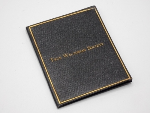 F.M. Halford’s True Waltonian Society membership card, the folding rectangular black rexine booklet gilt stamped society details within a lined border, interior with printed central club emblem vignette depicting two gentleman anglers flanking a central