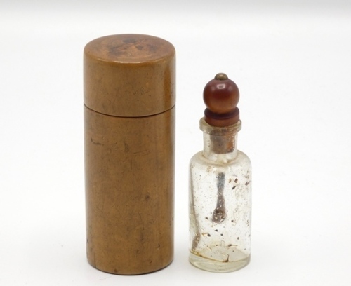 F.M.H.’s dry fly oil bottle and treen cannister, the shouldered glass bottle with treen knopped cork stopper and brush applicator contained within a turned fruitwood screw top cannister, 3 1/2" high overall, circa 1895 (see illustration)