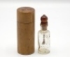 F.M.H.’s dry fly oil bottle and treen cannister, the shouldered glass bottle with treen knopped cork stopper and brush applicator contained within a turned fruitwood screw top cannister, 3 1/2" high overall, circa 1895 (see illustration)