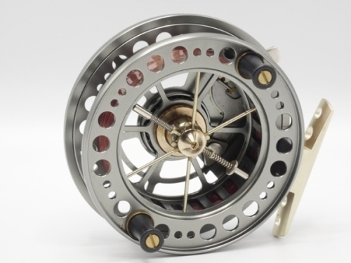 A J.W. Young’s Bob James Lightweight 3 ¾" centre in reel, graphite anodised finish, shallow cored drum with slotted arbour, six spokes, twin composition handles and release/regulator forks, pierced alloy stancheon foot, rim mounted optional check lever an