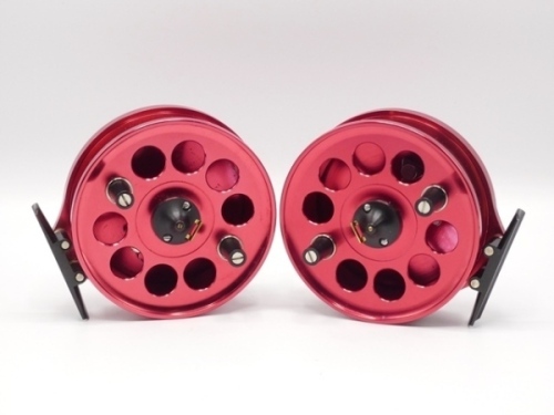 A pair of Browning 4" centre pin reels, red anodised finish, shallow cored drum with twin composition handles and spring latch, stancheon foot, rear sliding optional check button and bar spring check mechanism, one un-named, both in little used condition