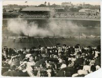 Sydney Cricket Ground. An early mono press photograph, dated to verso 1902, depicting a sports event at the Ground with large crowd in attendance. The activity on the pitch appears to a be a shooting display or competition. 10.5"x8". Loss to one corner an