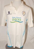 Derbyshire C.C.C. A match worn Derbyshire 1st XI white short sleeve shirt with blue trim, County emblem to chest and sponsor's logos to front and reverse. Player's name and number 'Groenewald 12' (Tim Groenewald, Derbyshire 2009-2014)) to reverse. Sold wi