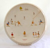 'The Brownies (Cricket)' circa 1910. Large circular ceramic platter decorated with images of 'Brownies' cricketers playing cricket to inside. The images include batsmen, bowler, fielders, wicket keeper, umpires, crowd in a small marquee', batsman awaiti