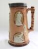 Cricketing jug. A large and impressive Doulton Lambeth stoneware tapering jug, moulded in relief with six raised figures, three of batsman and three of fielders in roundels, all different and in various positions. With two further smaller raised figures o