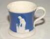 Staffordshire blue ground waisted cricket mug with strap handle and beaded rim. With three relief moulded figures of a batsman, bowler and wicket keeper in cream, believed to be Lillywhite, Pilch and Box. c1860. Two minor chips to rim otherwise in good co