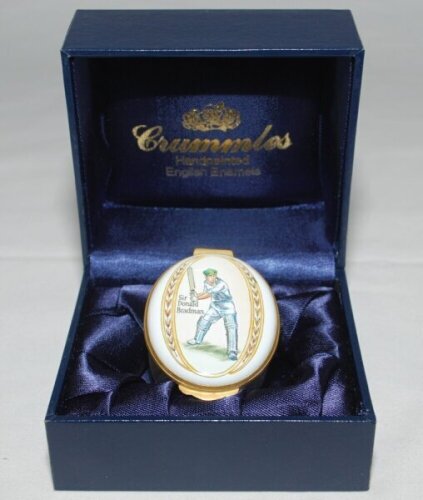 Cricket pillbox. Sir Donald Bradman. Modern enamelled oval pillbox hand decorated with a portrait of Bradman standing full length in batting pose. In original box with certificate of authentication. Produced by Crummles of Poole, Dorset. VG - cricket