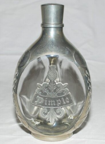 E.W. 'Jim' Swanton. Glass and pewter 'Haig Dimple' whisky decanter with 'Dimple' motif pewter panel to one side, with floral decorations, 'Haig', and coats of arms to sides. Maker's mark for Daalderop Royal Holland Pewter, no. N4919 to base. 8.5" tall. Ac