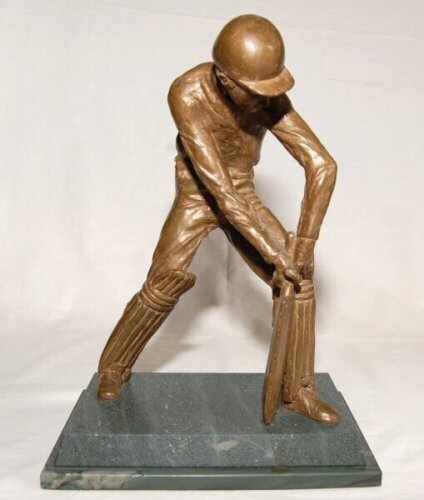 'Evening Standard Cricketer of the Month'. Large and heavy 'float bronze' sculpture of a of a batsman wearing cap in batting pose playing a forward defensive shot. The figure mounted on a marble plinth. The figure stands 10.5 tall. Similar trophies were a