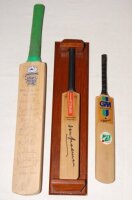 Don Bradman. Miniature Gray Nicholls bat nicely signed to the face by Bradman. 11.5", in wooden display stand. Sold with a Yorkshire C.C.C. miniature bat signed to the face by eleven Yorkshire players c. 1997. Signatures include Byas, Moxon, Gough, White,