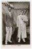 R.F. & H.L. Doherty. Rare original and early mono real photograph postcard of the brothers, Reginald 'Reggie' and Laurence 'Laurie' Doherty, standing full length holding rackets and wearing tennis attire, Reginald with a blazer, Laurie in a full length wh