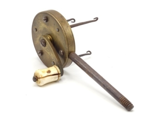 A scarce 19th Century brass gut twisting engine the 2" diameter circular brass gear housing fitted three iron pick-up gut hooks, curved crank winding arm and turned bone handle, mounted on threaded iron table screw (slightly short at tip), circa 1840 (see