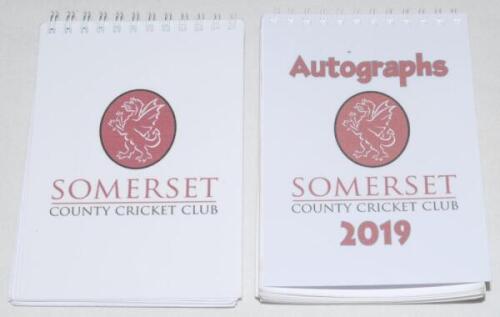 Somerset C.C.C. Two Somerset C.C.C. spiral bound autograph books, each page with individual colour player portrait. One undated (probably 2014) fully signed by all twenty six featured players, the other for season 2019 fully signed by all 28 featured play