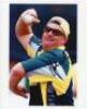 Shane Warne. Two colour press photographs, each signed to the photograph by Warne. Images depict a close-up of Warne in bowling action wearing sunglasses, and Warne celebrating taking a wicket against England. Both 10”x8”. VG