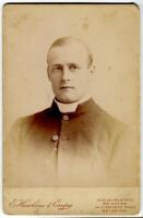 Reverend William Rashleigh. Oxford University & Kent, 1885-1901. Original sepia cabinet card photograph of Rashleigh, half length in religious cassock. Photograph by E. Hawkins of Brighton. Photographer’s name printed to lower border. Advertisement for Ha