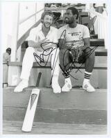 Ian Botham and Viv Richards. England tour to West Indies 1980/81. Original mono press photograph of England captain, Ian Botham sat in conversation with his Somerset team mate, Viv Richards, on the pavilion steps at Antigua. Signed in black pen to the pho