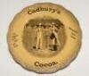 Cricket plate. ‘Cadbury’s Cocoa. The Oldest and still the best. Absolutely Pure Cocoa’. An advertising plate for Cadbury’s printed to centre with a cricket scene of a boy serving a cup of cocoa to a batsman during a game, wicketkeeper and fielders plus cr