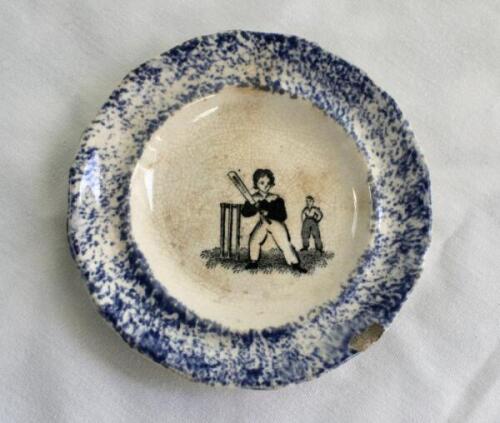 Child’s plate/dish. Small early Victorian Staffordshire child’s plate with centre image vignette of a boy batsman holding a bat in the air in front of the wicket with fielder behind, speckled blue outer border. 3.5” diameter. Circa 1860. Circular mark imp