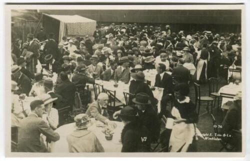 ‘Wimbledon 1914’. Rare original mono real photograph postcard showing the many spectators enjoying lunch outdoors, long table clothed tables with waitresses serving, ladies in hats and men in boaters etc. Card no. 076 in a series issued by Edwin Trim & Co