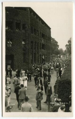 ‘Wimbledon Centre Court’ circa 1937. Original mono real photograph postcard showing the ivy wall of Centre Court with crowds milling around outside. Card no. F104 in a series issued by Edwin Trim & Co. of Wimbledon, publishers name printed to lower corner