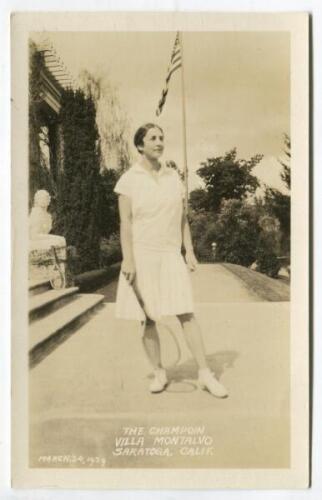 ‘The Champion. Villa Montalvo. Saratoga, Calif[ornia]. March 24th 1929’. Very rare privately printed original mono real photograph postcard of Helen Wills, eight times Wimbledon Champion, full length in tennis attire holding a tennis racket