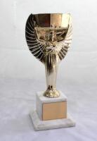 World Cup. Jules Rimet Trophy. Miniature replica of the Jules Rimet Trophy. The trophy, comprising of a decagonal cup, supported by a winged figure representing Nike, the ancient Greek goddess of victory, in gold metal and resin with ‘FIFA’ to foot, on a 