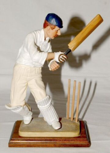 ‘The Cricketer’. Large stone ware resin figure of a batsman, thought to be of F.S. Jackson, wearing navy blue cap playing a shot with wooden stumps to plinth.