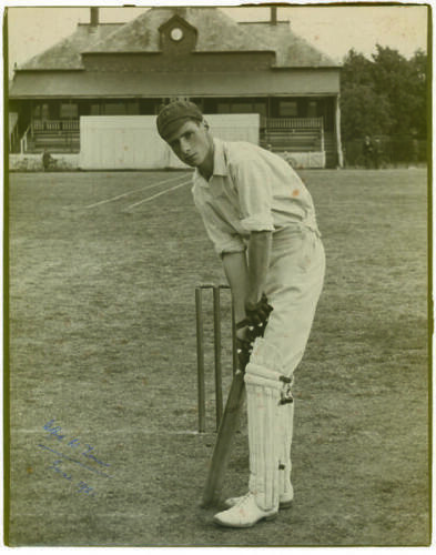 Wilfred Walter Timms. Northamptonshire 1921-1932. Excellent large original photograph of a youthful Timms, wearing cap and in batting stance in front of the wicket with pavilion to background. Signed to image in biro, in later years by Timms, and dated Ju