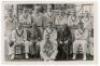 Derbyshire 1937. Mono plain back real photograph postcard of the Derbyshire team seated and standing in rows wearing cricket attire. The postcard with official stamp to verso for Albert Wilkes & Son, West Bromwich, with typed caption listing the players i