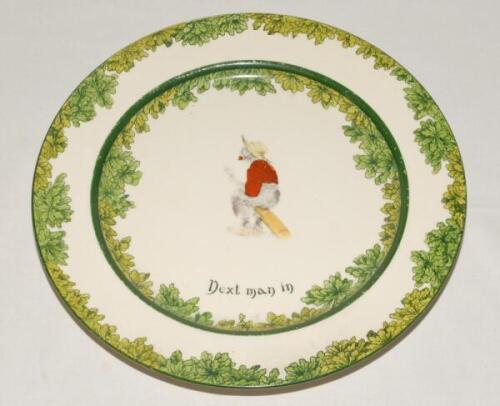 ‘Next Man In’. A Royal Doulton ‘Black Boy’ bone china dinner plate, entitled ‘Next Man In’ printed with a boy cricketer in red shirt, grey trousers and a floppy hat, sitting on his bat, waiting to go in. Green floral decoration to inner and outer rim. 10.