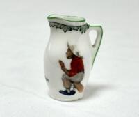 ‘Next Man In’. A Royal Doulton Black Boy miniature jug, entitled ‘Next man in’ printed with a boy cricketer in red shirt, grey trousers and a floppy hat, sitting on his bat, waiting to go in, title ‘Next Man In’ to centre and to verso, the crest ‘The All 