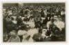 ‘Wimbledon 1914’. Rare original mono real photograph postcard showing the many spectators enjoying lunch outdoors, long table clothed tables with waitresses serving, ladies in hats and men in boaters etc. Card no. O34 in a series issued by Edwin Trim & Co