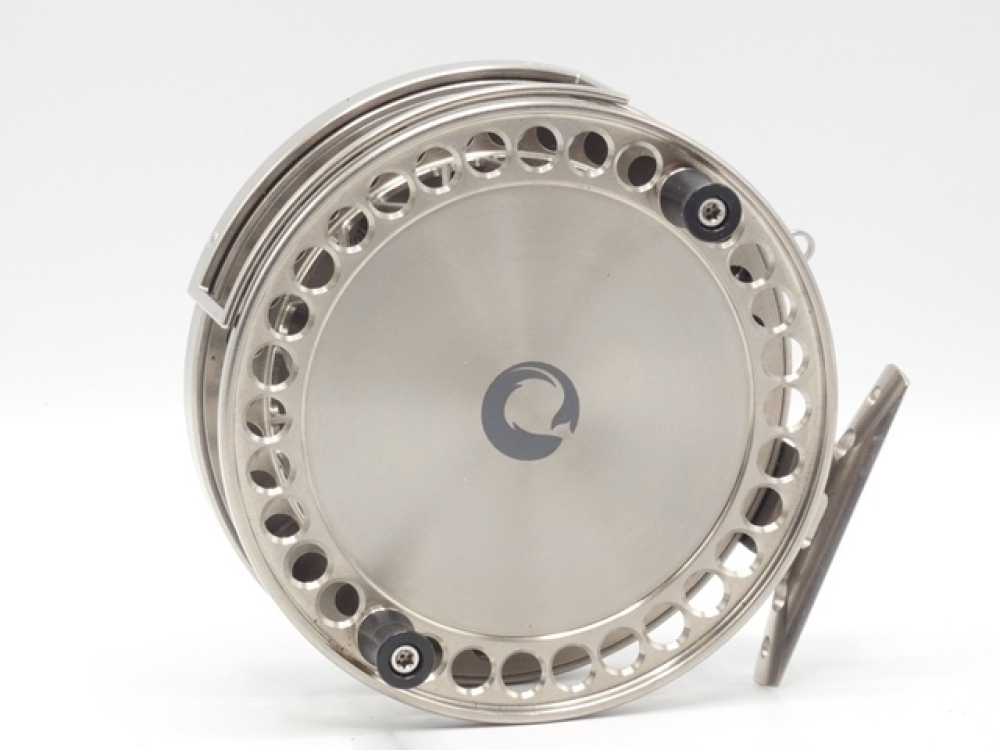 A rare Piscario Halcyon 4 ½ titanium centre pin reel, shallow cored narrow  drum with ventilated arbour, twin composition handles and perforated  flanges, Bickerdyke line guide, pierced stancheon foot, rim mounted optional