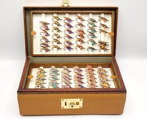 A fine Peter Loam handmade rectangular leather salmon fly reservoir, interior fitted four oak lift-out trays, each with silk covered fly bars and leather tab grips, holding a very good selection of 144 fully dressed modern salmon flies, various patterns a