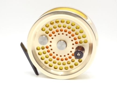 An Abel No. 4.5 salmon/saltwater 4 ½" fly reel and spare spool, gold anodised, left hand wind model with counter-balanced rosewood handle, perforated drum faceplate and rear milled spindle mounted tension adjuster, little used condition and in original ne